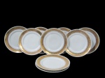 SCHMIDT, Nove pratos para sobremesa em porcelana esmaltada na tonalidade branca, com pintura de flores e folhagens em espessa faixa em vasta douração, apresenta falhas na douração. Med.: 20cm.