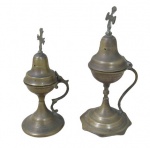ARTE SACRA, Dois incensórios, confeccionados em bronze, encimado por cruz, alça lateral vazada, 1 com base oitavada e 1 com base circular, ambos escalonados. 1 possui mossa na cruz. Med.: 23cm / 19cm.