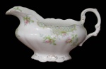 JOHN MADDOCK & SONS, Inglaterra, Molheira em faiança vitrificada na tonalidade creme, com pintura de flores, arabescos e folhagens em policromia, bordas onduladas realçadas em ouro, com falhas na douração e alça colada. Med.: 11x20,5x9cm.