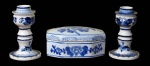 PORCELANA/FAIANÇA, Lote com 3 peças, sendo: A) 1 caixa em porcelana esmaltada na tonalidade branca, formato oitavado, com pintura de flores, folhagens e arabescos na tonalidade azul (6x13x9cm) e B) par de castiçais em faiança vitrificada. com pintura de flores e folhagens na tonalidade azul e realces na base e na bobeche (12cm).
