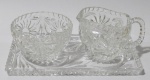 CRISTAIS, Lote com 3 peças confeccionadas em cristal translucido, ricamente lapidado por flores e folhagens, sendo: A) 2 molheiras, sendo 1 com alça (7x10x7,5cm / 5x8,5cm) e B) 1 bandeja retangular (19x11cm).