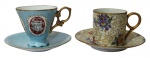 PORCELANA, Lote com 2 xícaras de coleção com seus respectivos pires, sendo: A) 1 da manufatura STEATITA, confeccionada em porcelana esmaltada na tonalidade branca, com pintura de flores e folhagens em policromia e realces em ouro (5x8x5,5cm / 11cm) e B) 1 em porcelana esmaltada na tonalidade azul, com pintura de figuras gregas sobre esmaltagem vermelha, alças e bordas filetadas a ouro (6x8,5x6,5cm / 10,5cm).