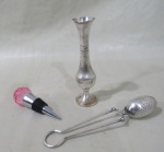 METAL PRATEADO, Três peças em metal, sendo: A) 1 vaso solifleur em metal espessurado a prata, possui mossas na borda, apresenta falhas na prateação (13,5cm), B) 1 coador de chá em metal espessurado a prata (17cm) e C) 1 tampa de garrafa em metal prateado, terminado por esfera facetada em cristal na tonalidade rosa (9,5cm).