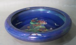 DEVON LUSTRING FIELDING'S, Inglaterra, Centro de mesa em faiança inglesa vitrificada esmaltada na tonalidade azul furtacor, com pintura de barco e pássaros em policromia, borda decorada com arabescos em ouro (falhas na douração). Grande bicado na borda e pequeno na base. Med,: 6x30cm.