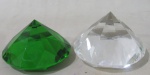 CRISTAIS, Dois pesos de papel, confeccionado em cristal, em formato de diamante, sendo 1 na tonalidade verde e 1 translucido. Med.: 5x8cm.