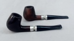 CACHIMBOS, dois (2) distintos, ambos com fornilho em madeira (um deles com rachados na borda), marcado em cavo EB no outro, anel em metal piteira em baquelite ou símile, usados, medindo 15,5 cm comprimento.