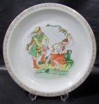 CHODZIEZ, Polônia, Medalhão em porcelana polaca esmaltada na tonalidade branca com pintura campestre em policromia, borda com guirlanda floral em ouro. Med.: 31cm.