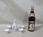 SAKE GEKKEIKAN - Conjunto para saque, composto de: 1 garrafa GEKKEIKAN, 1 garrafa em porcelana esmaltada na cor branca com pintura de folhagens na tonalidade azul, e 4 copinhos m porcelana com pintura de folhagens na tonalidade azul. Med.: Bebida: 30cm / Garrafa: 13cm / Copinho: 4x5,5cm.