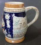 CERAMARTE - Caneca em faiança esmaltada com rica policromia decorada com cenas do cotidiano em relevo. Marcado no fundo. Med.: 14,5x13cm.