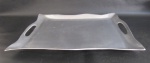 METAL PRATEADO - Bandeja em alumínio polido com bordas onduladas e alças laterais vazadas. Med.: 46,5x35cm.
