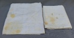 CAMA E MESA, lote com duas (2) toalhas de mesa, uma confeccionada em algodão com estampa floral do próprio tecido, na tonalidade branca, medindo aproximadamente 270x130 cm, e a outra confeccionada em tecido de linho, na tonalidade branca, com bordados quadrangulares desfiados, medindo aproximadamente 170x144 cm; usadas, com manchas, bordados desfiados se desfazendo.