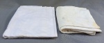 CAMA E MESA, lote com duas (2) toalhas de mesa, confeccionadas em algodão branco, na tonalidade branca, com estampa floral no próprio tecido, uma medindo aproximadamente 200x120 cm, e a outra medindo aproximadamente 185x160 cm; usadas, uma com remendos, furos, esgaçados e manchas, e a outra com manchas e sinais de uso.
