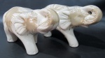 ESCULTURAS - Duas esculturas confeccionadas em faiança esmaltada e vitrificada em tons de creme, representando elefantes. Medidas alt 16 cm x comp 28 cm x larg 9 cm.