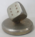 ESCULTURAS - Peso para papel em bronze representando dado de jogos sobre base circular. Med.: 6,5cm.