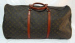 ACESSORIOS FEMININOS, Bolsa de viagem LOUIS VUITTON, confeccionada em couro sintético, guarnições em metal dourado com sinais de oxidação, pequena falha na costura como mostra a foto extra. Med.: 35x60cm. Não é original.