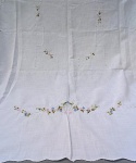 CAMA E MESA, lote com uma (01) toalha, confeccionada em linho, na tonalidade branca, decorada com crivos, bordado desfiado e bordado floral policromado, medindo aproximadamente 210x140 cm; usada, com manchas.