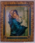Ícone, ao centro estampa sobre papel, repres. Maternidade, sobre placa de madeira decorada em folha de ouro e policromia, med. 55 x 45 cm.