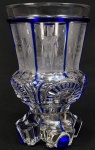 IMPÉRIO AUSTRÍACO  FERNANDO I (1793-1875)  IRMÃO DA IMPERATRIZ BRASILEIRA MARIA LEOPOLDINA. PRECIOSO GOBLET EM CRISTAL DA BOHEMIA NAS TONALIDADES AZUL COBALTO E TRANSLÚCIDO. BOJO LAPIDADO EM FACETAS COM VIRTUOSA LAPIDAÇÃO COM MONUMENTOS AUSTRÍACOS E EFÍGIE EM CORPO INTEIRO DO IMPERADOR FERNANDO I TRAJANDO UNIFORME MILITAR. A BASE DENTADA É REMATADA POR GOTAS EM PROFUNDO AZUL COBALTO. ÁUSTRIA, DEC. 1840. 14,5 CM DE ALTURANOTA: Fernando I & V (Viena, 19 de abril de 1793  Praga, 29 de junho de 1875) foi o Imperador da Áustria e Rei da Lombardia-Vêneto como Fernando I e também Rei da Hungria, Croácia e Boêmia como Fernando V de 1835 até sua abdicação em 1848 devido às Revoluções de 1848. Era o filho homem mais velho do imperador Francisco I e sua segunda esposa Maria Teresa da Sicília. Fernando desde a infância possuía uma doença mental e assim era incapaz de governar pessoalmente seu império, com um conselho regencial sendo estabelecido após sua ascensão formado por seu tio o arquiduque Luís da Áustria e os políticos Franz Anton von Kolowrat e Klemens Wenzel von Metternich. Fernando abdicou em dezembro de 1848 em favor de seu sobrinho Francisco José I devido a revoluções liberais, indo viver no Castelo de Praga até morrer aos 82 anos em 1875.