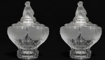 BACCARAT CORNAC -  PRECIOSO PAR DE  COMPOTEIRAS EM CRISTAL TRANLÚCIDO COM DETALHES EM SATINE DA MANUFATURA BACCARAT COM A DESEJÁVEL DECORAÇÃO DITA CORNAC (ADESTRADOR DE ELEFANTES). ROBUSTAS E PESADAS ESSAS LINDA COMPOTEIRAS TEM PEGAS LATERAIS COM FEITIO DE MAGNIFICAS CABEÇAS DE ELEFANTES CUJAS TROMBAS ESTENDEM-SE ATÉ A BASE. ENTRE AS PEGAS LUXUOSOS DRAPEADOS COM FEITIO DE CORTINAS INDIANAS PROLONGANDO-SE A PARTIR DAS ORELHAS DOS PAQUIDERMES. NO TERÇO INFEIRIOR O CRISTAL TRANSLÚCIDO DE FORMIDÁVEL LUMINESCÊNCIA É DECORADO COM CANELURAS. A TAMPA TEM PEGA NO FEITIO DE JOVEM MENINO CARACTERIZADO COMO CORNAC, UM ADESTRADOR DE ELFANTES, SENTADO SOFRE ALMOFADA, TRAJANDO ROUPAS ETNICAS COM TURBANTE E MANTO E COM SUAS PERNAS CRUZADAS. FRANÇA, SEC. XIX. 26 CM DE ALTURA (UMA DELAS IMPECÁVEL E A OUTRA TEM TRINCA NO INTERIOR)