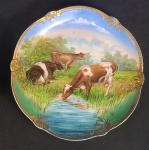 LINDO MEDALHÃO EM PORCELANA REPRESENTANDO FIGURAS DE VACAS A BEIRA DE RIACHO. BORDA COM ARREMATES EM OURO. ASSINADO PELO ARTISTA (R. K. BECK) FRANÇA, SEC .XIX. 30 CM DE DIAMETRO