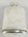 ASPREY & CO - GRANDE HIP FLASK (GARRAFA PORTÁVEL PARA BEBIDA) EM PRATA DE LEI COM MARCAS PARA CIDADE DE BIRMINGHAM, PRATEIRO ASPREY & CO E LETRA DATA PARA O SEC. XX. NA ROLHA INSCRIÇÃO ASPREY.  DE GRANDE FORMATO E CAPACIDADE PARA 500 ML ESSA GARRAFA EM PRATA DE LEI É DECORADA COM BELOS GUILLOCHES COM LINDOS FAISÕES EM VÔO ENTRE RAMAGENS E ARREMATE COM BELA ROCAILLE. A DECORAÇÃO SUGERE O USO EM CAÇADAS. A TAMPA É ROSQUEÁVEL PAR EVITAR VAZAMENTO DA BEBIDA. INGLATERRA, SEC. XX. 19 X 11,5 CM. 435 GNOTA: O hip flaskl começou a aparecer na forma que é hoje reconhecido no século XVIII, inicialmente utilizado por membros da pequena nobreza . Versões menos compactas já estavam em produção há vários séculos. Notavelmente, na Idade Média , há vários relatos de frutas evisceradas sendo usadas para armazenar bebidas alcoólicas. Durante o século XVIII, as mulheres que embarcavam em navios de guerra britânicos atracados contrabandeavam gim para dentro do navio em frascos improvisados, criados a partir de bexigas de porco e escondidos dentro de suas anáguas . Após o ato de proibição na América da década de 1920 , o estado de Indiana proibiu a venda produção desses. Frascos antigos, especialmente aqueles feitos de prata, são agora itens de colecionador muito procurados.