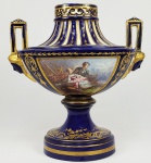 LINDO CENTRO DE MESA EM PORCELANA DE SEVRES - FUNDO EM AZUL COBALTO REMATADO POR  OURO. ALÇAS LATERAIS SE ELEVAM PARTINDO DE CARIÁTIDES. RESERVAS COM ESMALTES FLORAIS E CENA DE GALANTEIO. MARCAS DA MANUFATURA SOB A BASE. FRANÇA, SEC. XIX. 29 X 29 CM