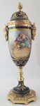 SEVRES - ANFORA EM PORCELANA AZUL COBALTO COM BRONZERIA ORMOLU. ALÇAS COM FEITIO DE CARIÁTIDES. DECORADA COM CENAS DE GALANTEIO, ARREMATES EM OURO. FRANÇA, INICIO DO SEC. XX. 25 CM DE ALTURA