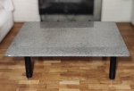 Mesa de centro com pés em ferro pintado de preto, tampo em granito na cor cinza. Mede 120 cm de comprimento x 90 cm de largura x 35 cm de altura.