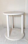 Mesa lateral com 2 estágios no formato circular, 3 colunas no formato cilíndrico, patinada de branco. Mede 50 cm de diâmetro.