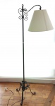 Luminária de chão, em ferro com pé tripóide e braço trabalhados, cúpula em tecido na cor bege. Mede 157 cm de altura.