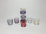Seis peças, sendo: 1 Jarra para licor em vidro decorado com motivo de flores em overlay, faixa na cor lilás, contornos em ouro - anos 50. Acompanha 5 copos para aperitivo de cores variadas iridescentes, anos 50.  Alt. jarra 20cm e diâm. 10cm.
