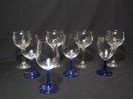 Oito taças de modelos diferentes, sendo 4 translúcidas (com 17 cm de altura) 4 com corpo translúcido e pé na cor azul. Todas com formato e tamanhos diferentes.