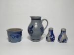 Quatro itens em cerâmica alemã nos tons de azul, sendo 1 jarra com 16 cm de altura, 1 bowl de 7 cm de altura e 9 cm de diâmetro  e 1 saleiro e 1 pimenteiro. Decorados em azul no estilo borrão.