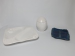 Três peças, 2 petisqueiras em cerâmica, sendo 1 branca decorada com frutas com dois compartimentos medindo 29 cm x 26 cm, 1 na cor azul em cerâmica vitrificada rústica medindo 19 cm x 17 cm e pote branco no formato de ovo com tampa, medindo 15 cm de altura.