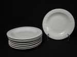 Oito pratos em porcelana branca com bordas decoradas, sendo 4 rasos com bordas decoradas com motivo de flores e 4 fundos com bordas decoradas com motivos de folha de parreira. Medem 20 cm de diâmetro.