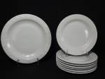 Oito pratos em porcelana, sendo 7 pratos rasos e 1 para bolo. Borda decorada com folhas de parreira. Diâmetro 26cm. Prato para bolo 32 cm de diâmetro.