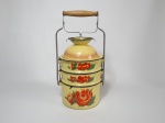 Conjunto de marmitas em metal esmaltado na cor amarelo, decorado com motivo de flores, com 3 compartimentos, a tampa no formato de bowl com pé redondo, gancho em metal e pega em madeira. Medem 15 cm de diâmetro e 27 cm de altura.