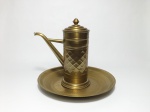 Duas peças em metal dourado, sendo 1 prato no formato redondo, martelado, medindo 29 cm de diâmetro e 1 bule em metal dourado com corpo trabalhado (falta a alça). Alt. 24 cm.