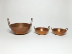 Três tachos em cobre martelado, de tamanhos diferentes, sendo os 2 menores com alça em bronze. Alt. maior 7cm x 19cm diâm. e 12cm diâm.