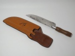 Grande faca no estilo peixeira, com bainha de couro, marcado na bainha Churrascaria BARBACOA. Mede 37 cm de comprimento, lâmina em aço inox, cabo de madeira (apresenta marcas de ferrugem na lâmina). No estado.