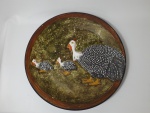 Grande medalhão em cerâmica, decorado com motivos de galinhas d´Angola. Mede 47 cm de diâmetro x 47 cm de altura.