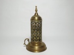Porta vela em cobre com alça, corpo vazado, base circular com uma alça. Origem árabe.