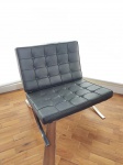 Poltrona modelo BARCELONA criado pelo designer Mies van de Rohe, estrutura de metal cromado, assento e encosto em couro sintético preto. Uma das tiras do encosto, solta.