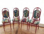 Quatro cadeiras no estilo Thonet, madeira vergada pintada de vermelho. Assento e encosto estofados de tecido no estilo Kilim com geométricos. Uma cadeira necessita restauro.