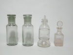 Quatro vidros de Pharmacia, translúcidos, de modelos e tamanhos diferentes. O maior mede 13,5 cm de altura (1 com tampa adaptada).