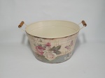 Grande cachepot em metal pintado e decorado com motivo de flores, com 2 alças, medindo 34 cm de diâmetro e 18 cm de altura.