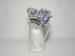 Vaso em metal trabalhado, patinado de branco, com arranjo de lavandas. Mede 20 cm de altura.