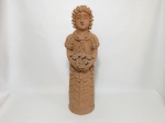 MARIA DE NUCA (Maria Gomes da Silva - Tracunhaém, PE) "Mulher segurando flores" Escultura em barro cozido. Assinada no verso.  Pequenos defeitos nas flores. Alt. 53cm.