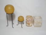 Quatro velas: 2 redondas com suporte metálico, 1 cilíndrica incrustada com conchas e 1 retangular incrustada com conchas e estrelas do mar.  Alts. 14 a 29cm.