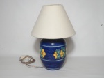 Abajur em porcelana azul decorado com flores amarelas e folhagem. Cúpula em tecido branco. Alt. 36 cm.